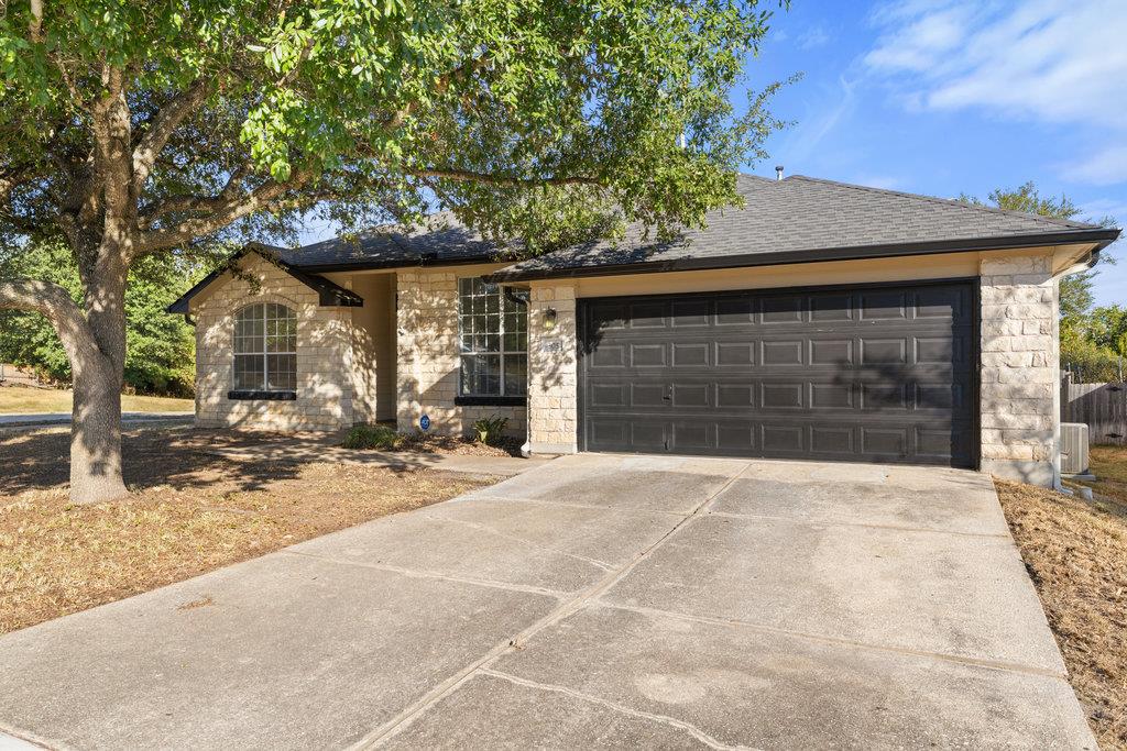 Single story home with stone siding, concrete dri