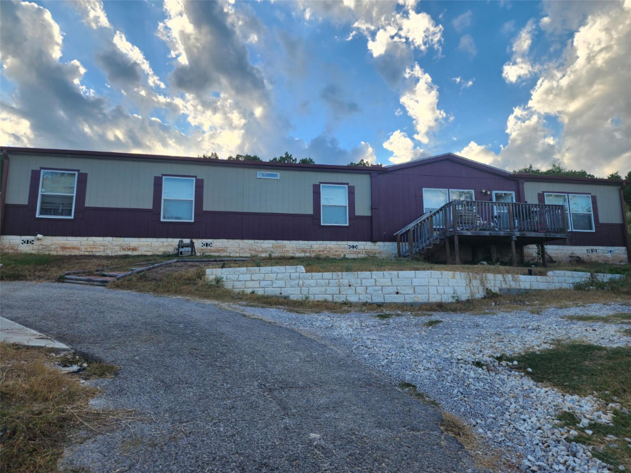 A long driveway leads up to this manufactured hom