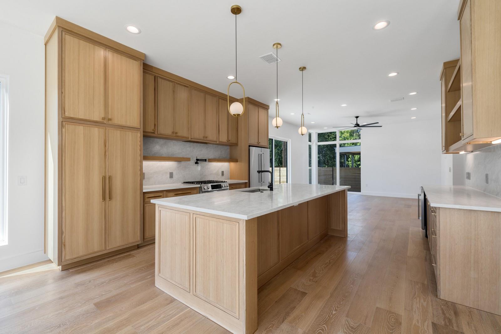 Kitchen with open shelves, tasteful backsplash, a