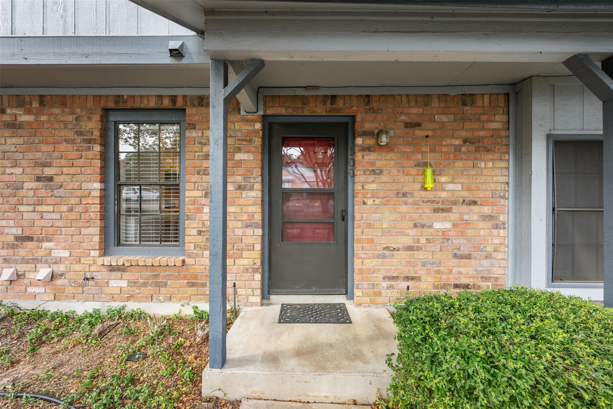 Doorway to property featuring brick siding, board