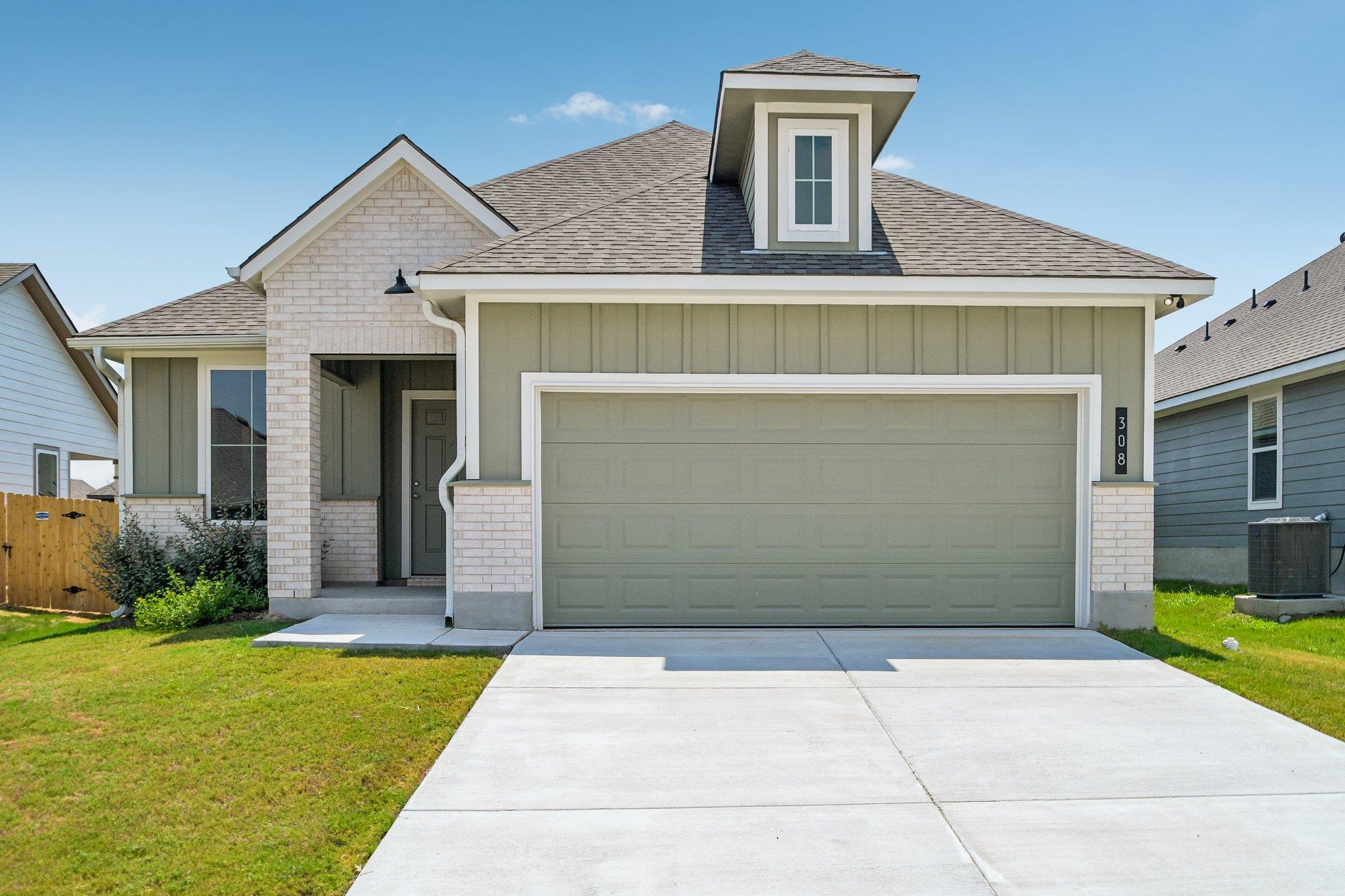 A concrete driveway leads to a two-car garage und