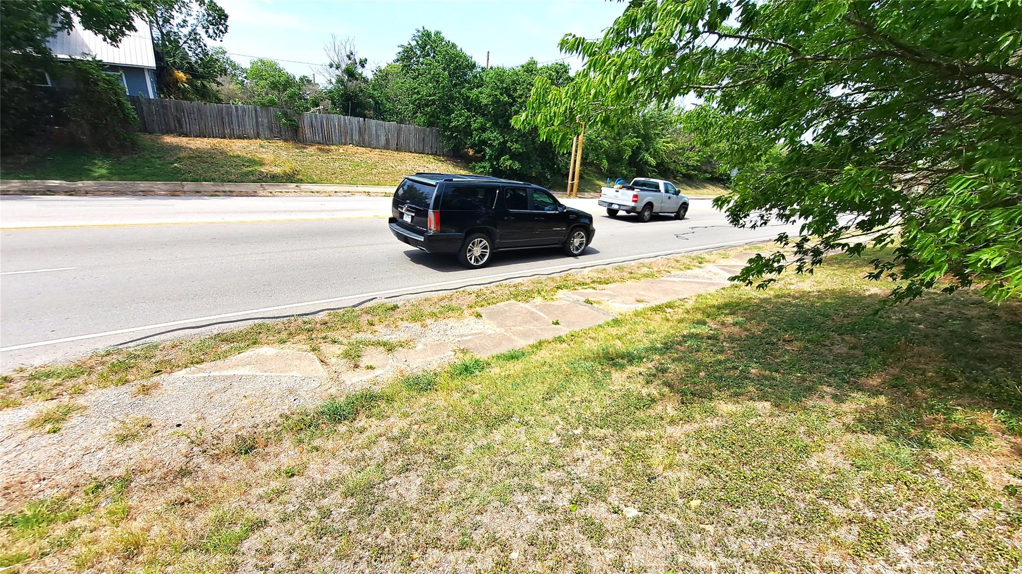 View of asphalt road featuring curbs