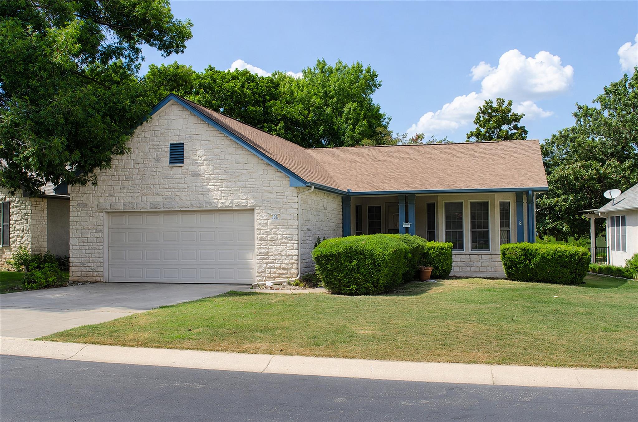 A welcoming stone facade home features an attache
