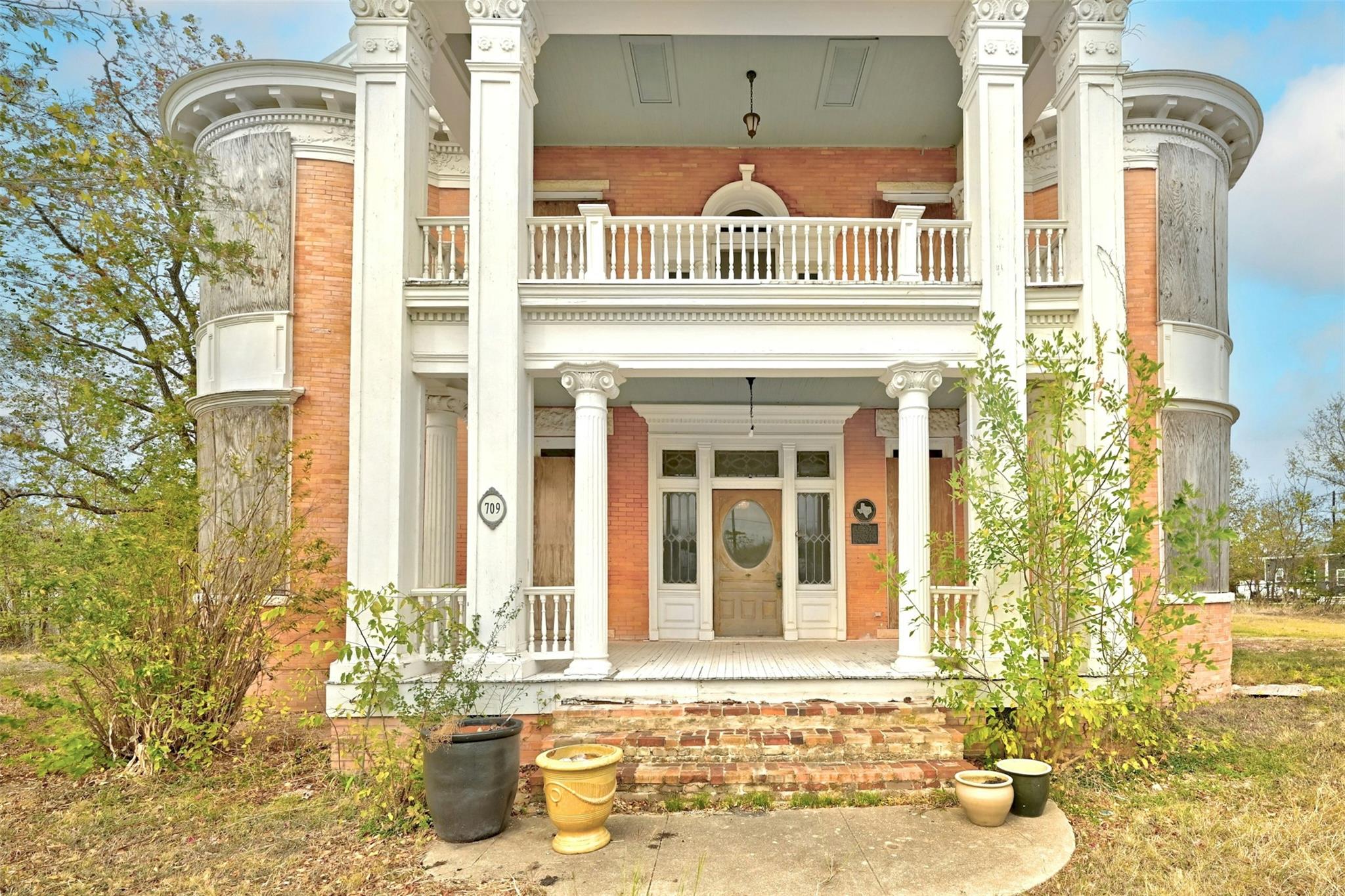 Property entrance with brick siding and covered p