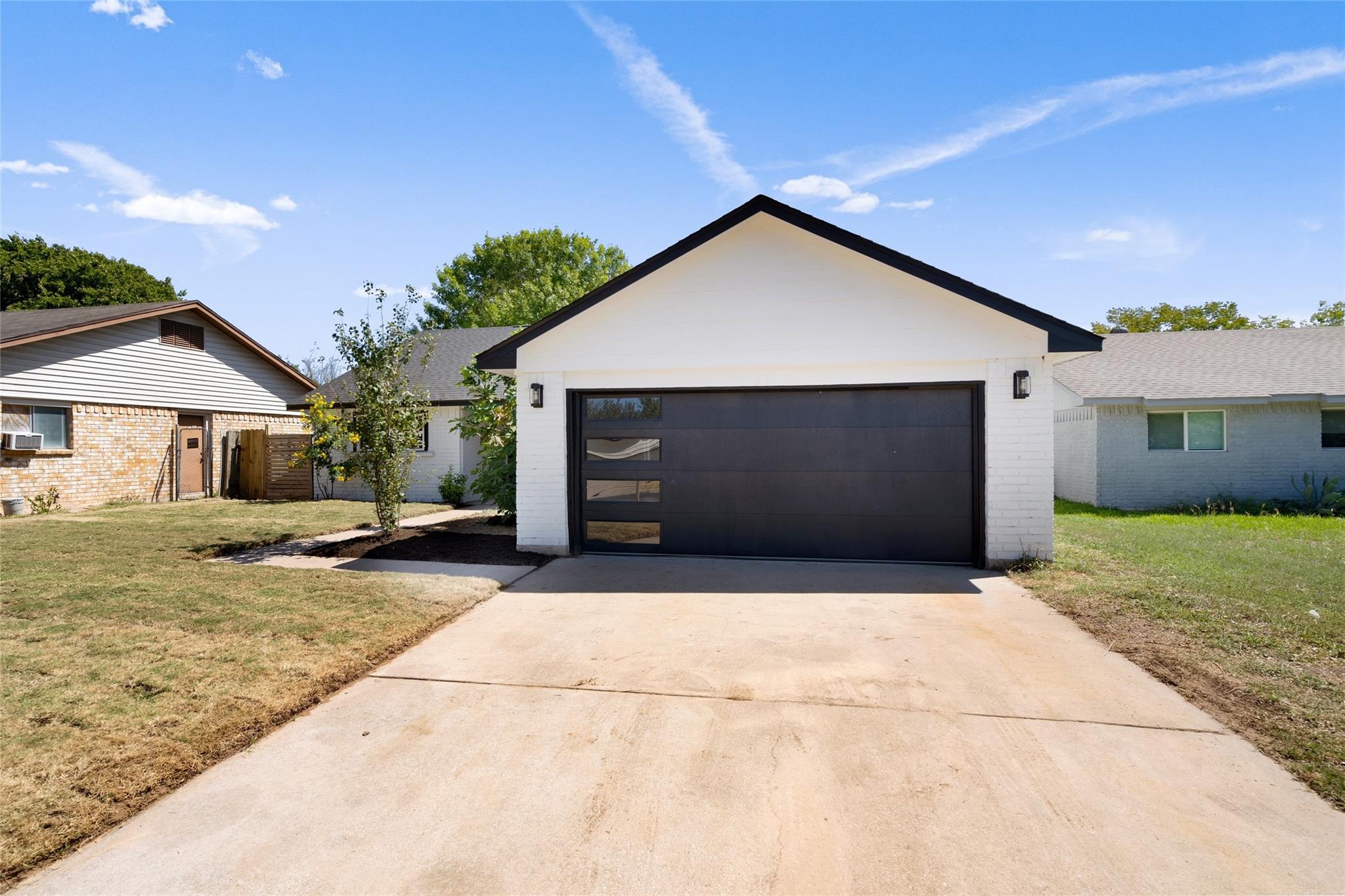 Ranch-style home with a front yard, a garage, and