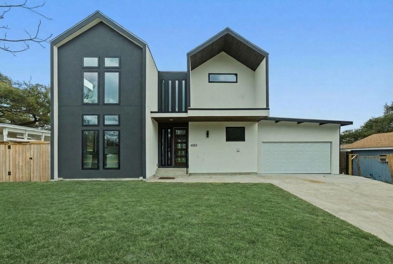 Rear view of house featuring stucco siding, drive
