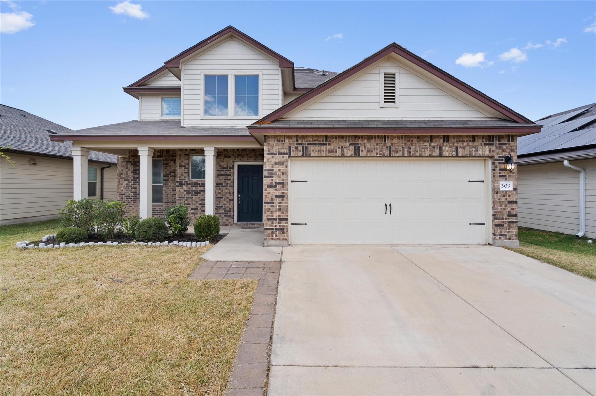 Brick accents and a classic front porch frame the