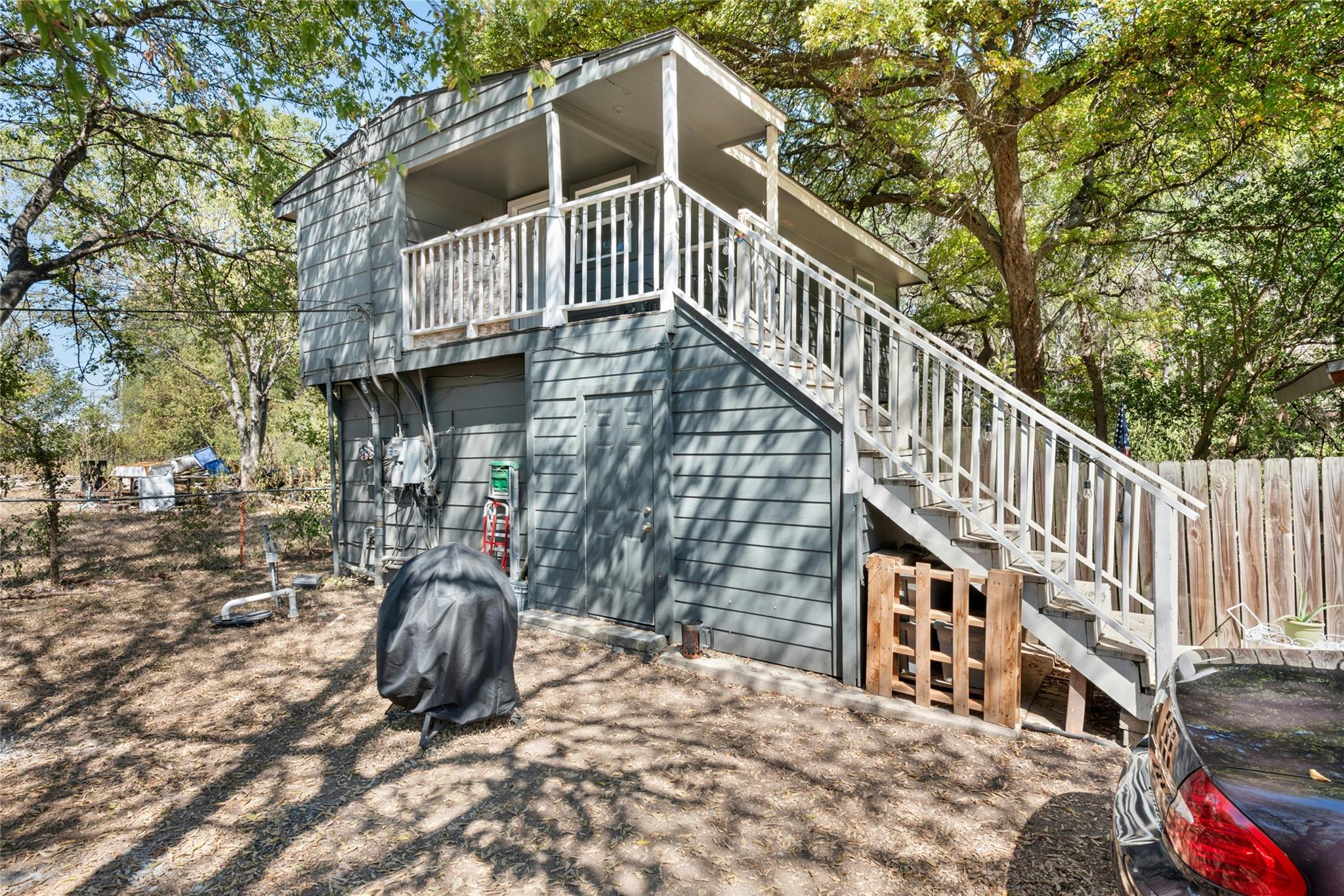 Rear view of property with stairs, a balcony, and