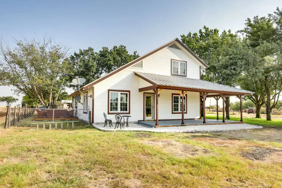 Back of house with covered porch and a metal roof