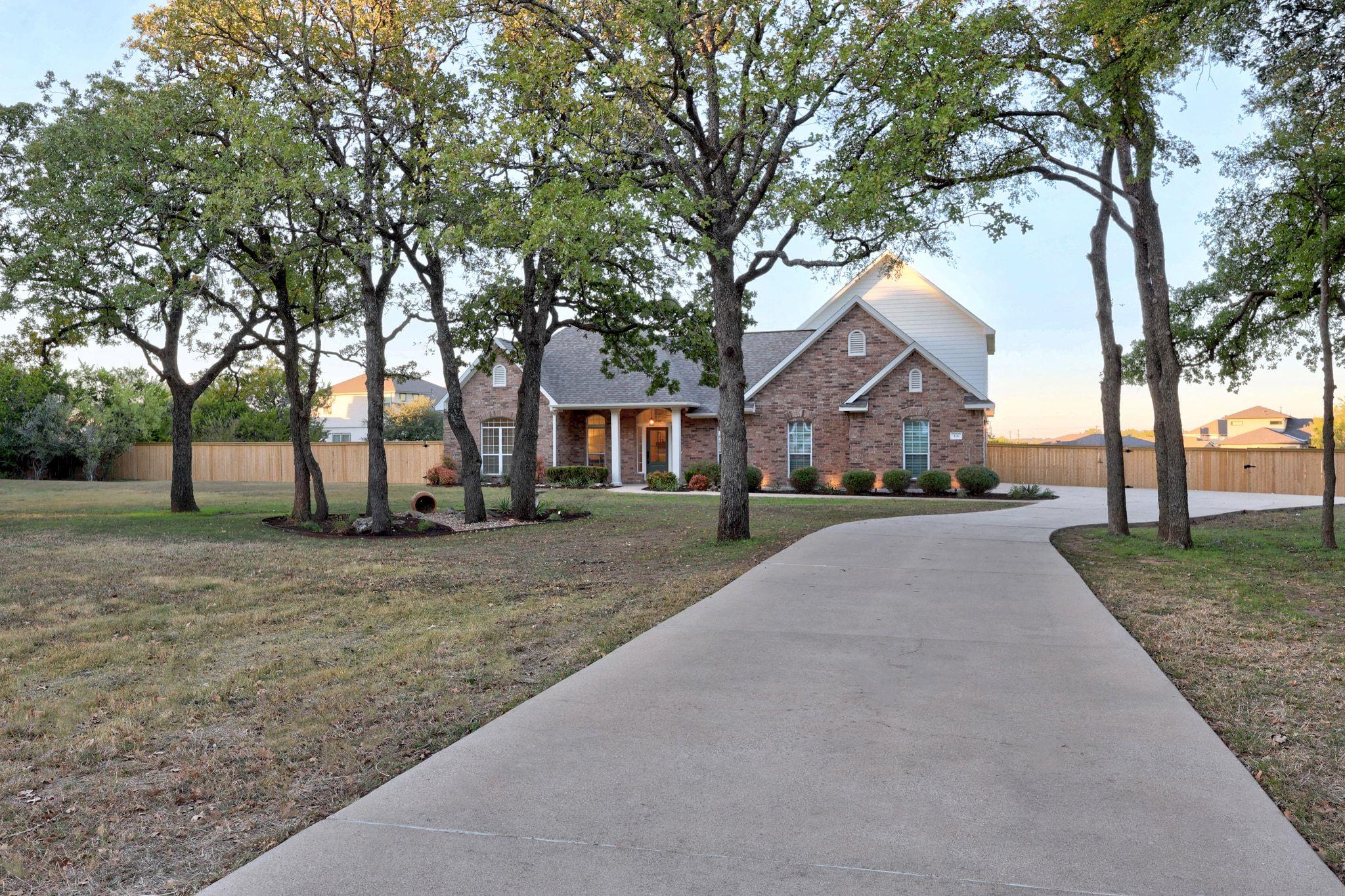 Brick exterior residence featuring a curved concr