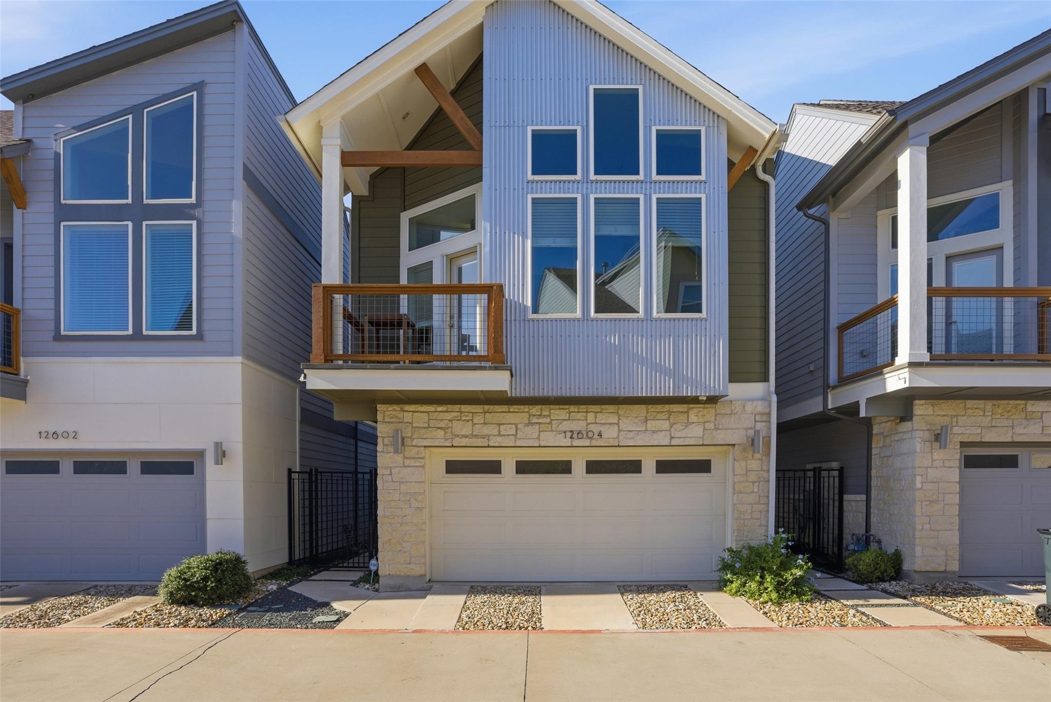 Contemporary home with a balcony, stone siding, c