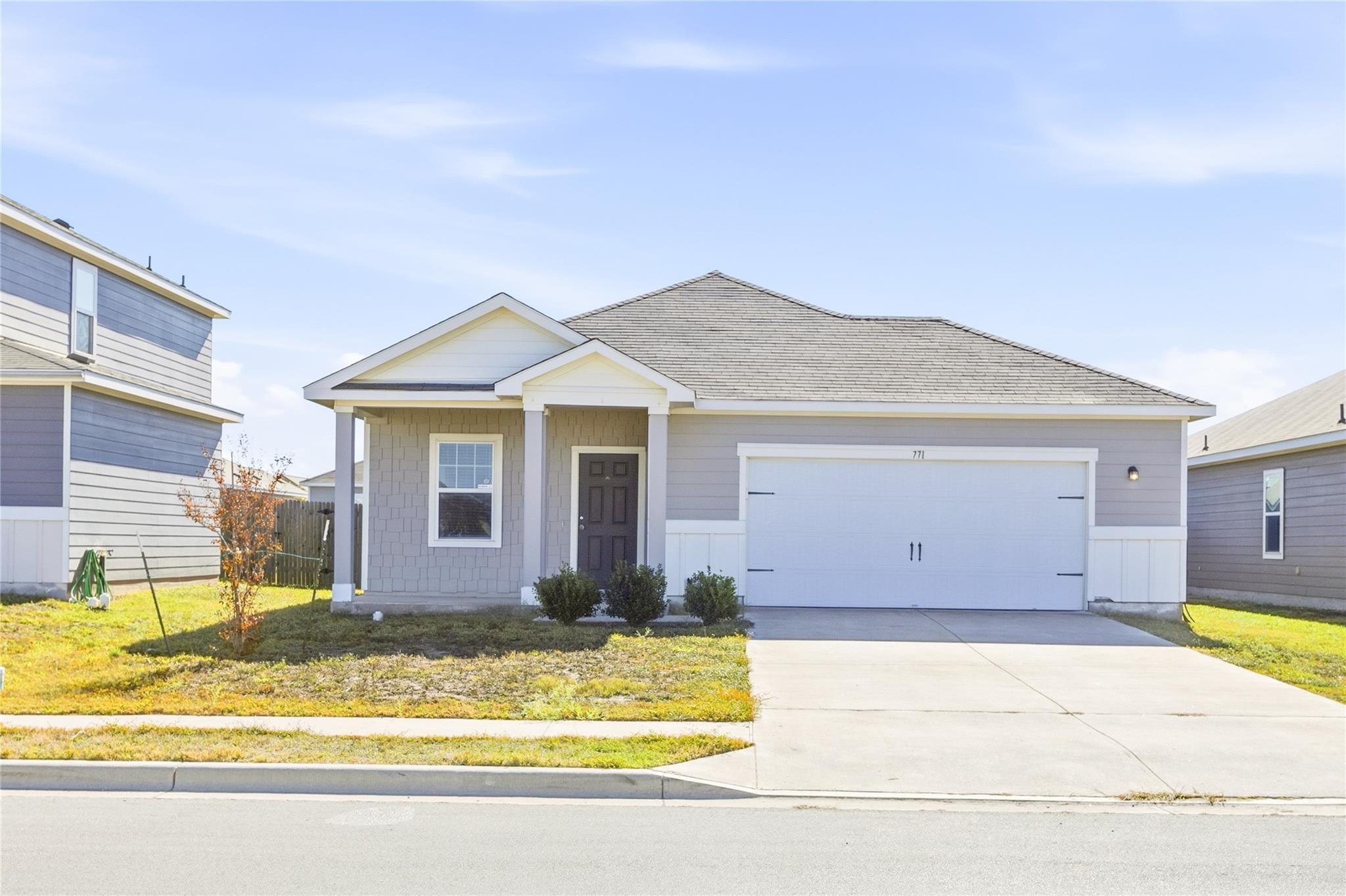 View of front facade featuring driveway, roof wit