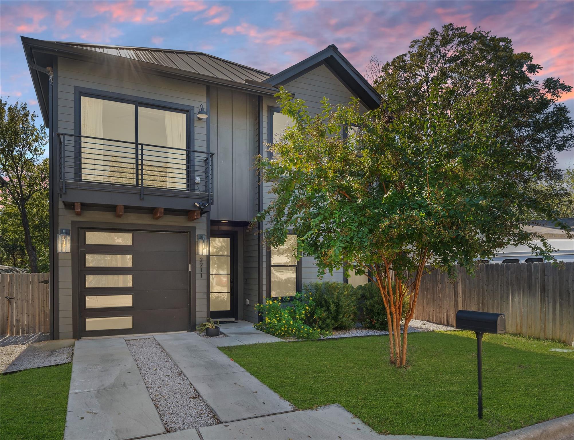 Contemporary house featuring a metal roof, a balc