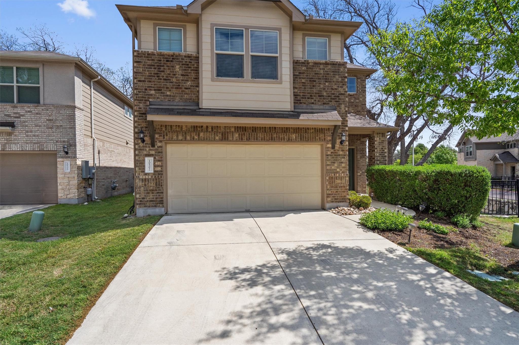 Traditional home with concrete driveway, brick si