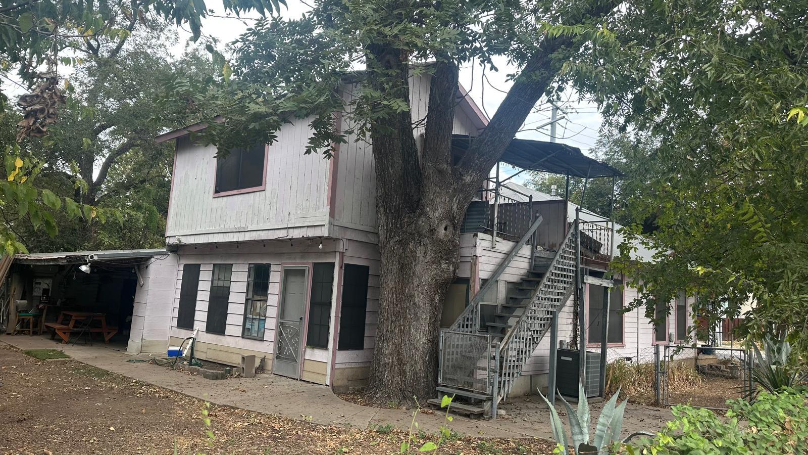 Back of house featuring stairs, a wooden deck, an