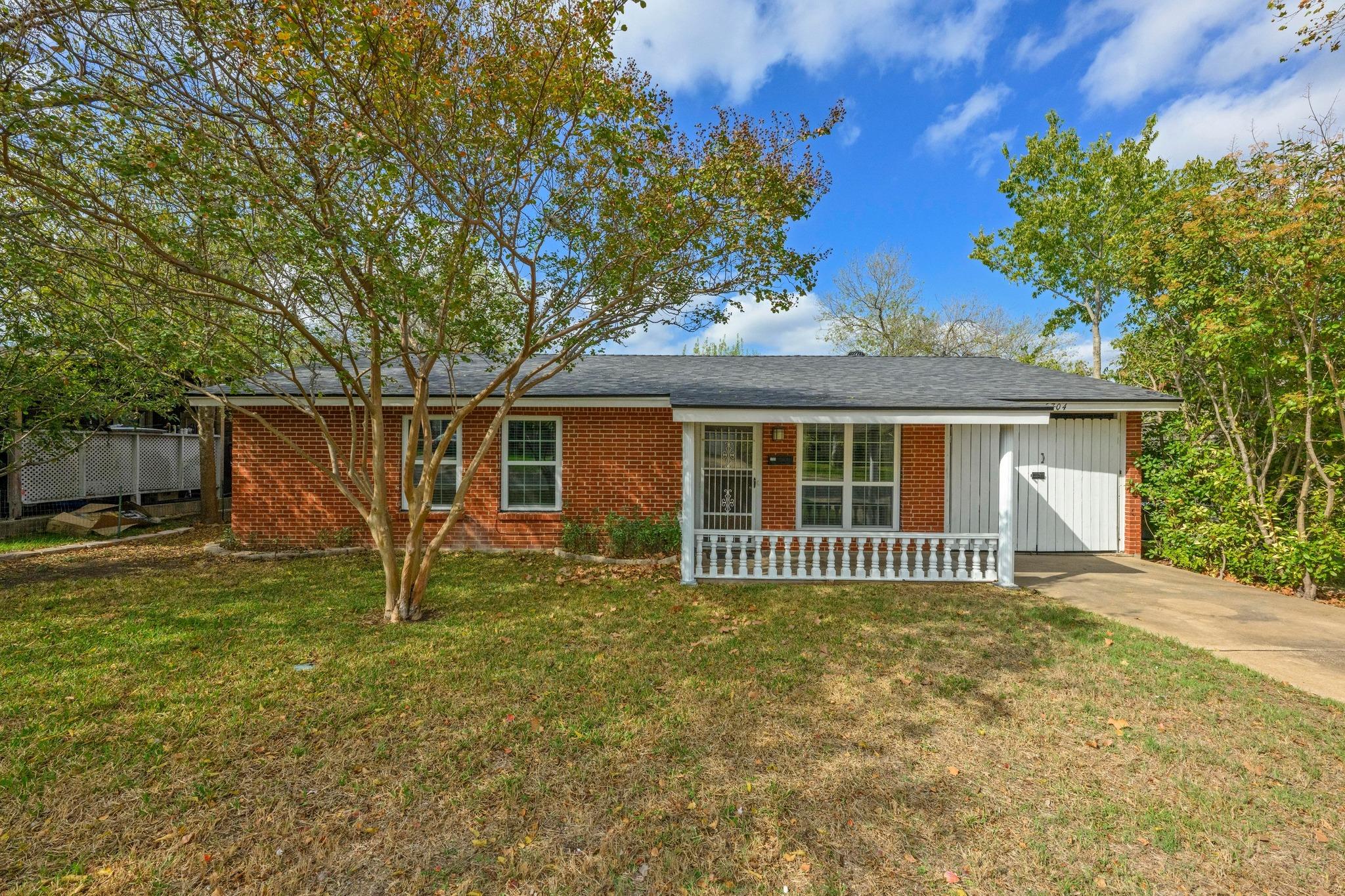 Ranch-style home with a front lawn, board and bat