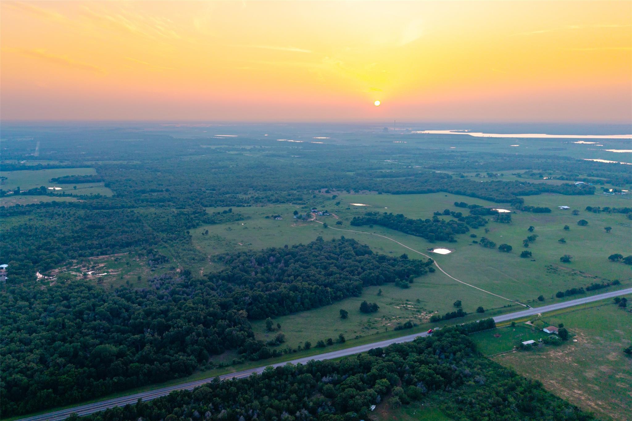 Expansive land parcel featuring a paved road fron