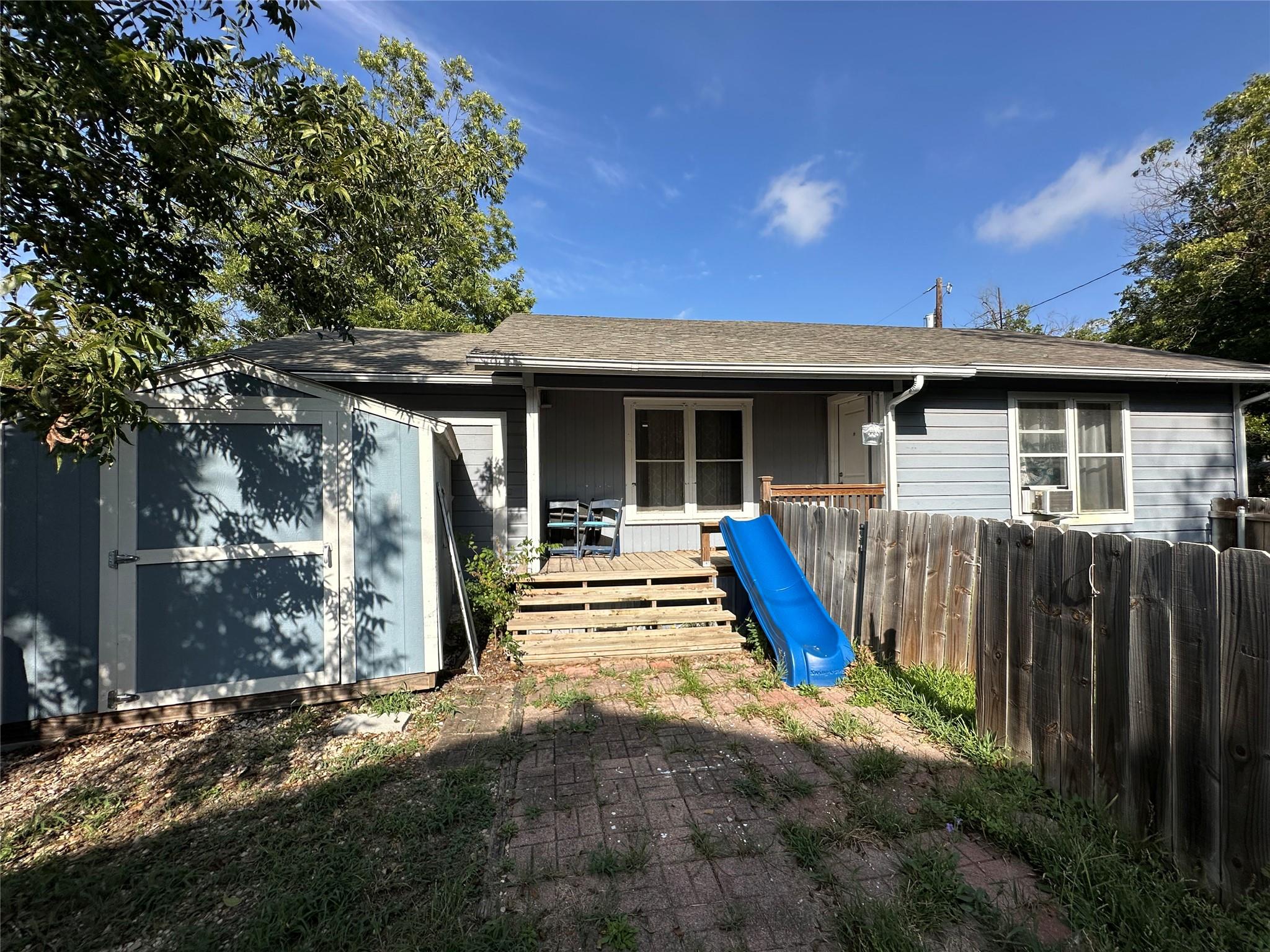 Rear view of property with a wooden deck, roof wi
