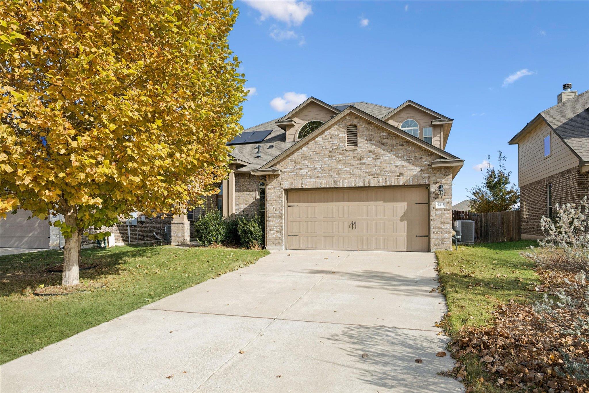 View of front facade with concrete driveway, bric