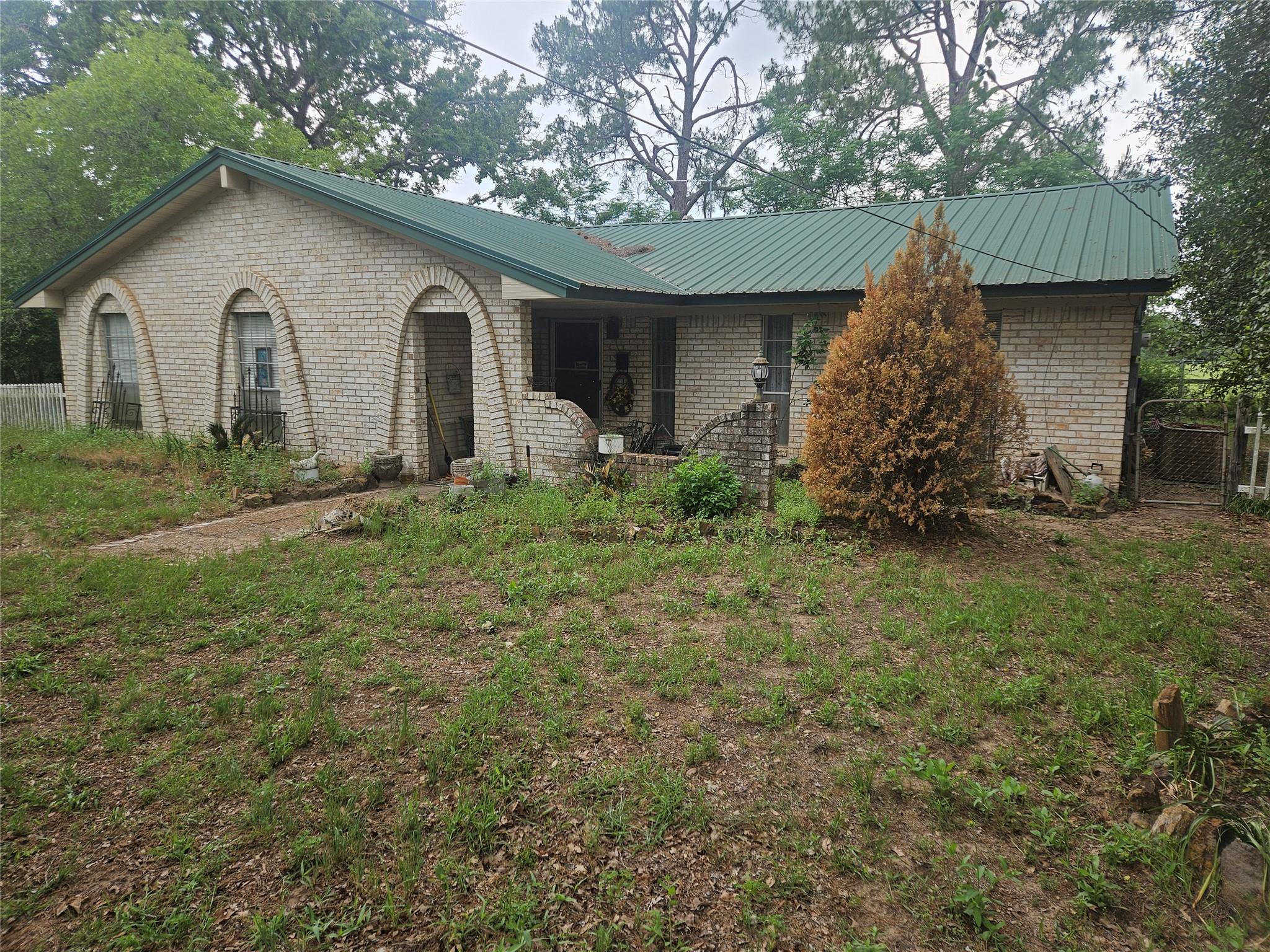 Single story home featuring brick siding and a me