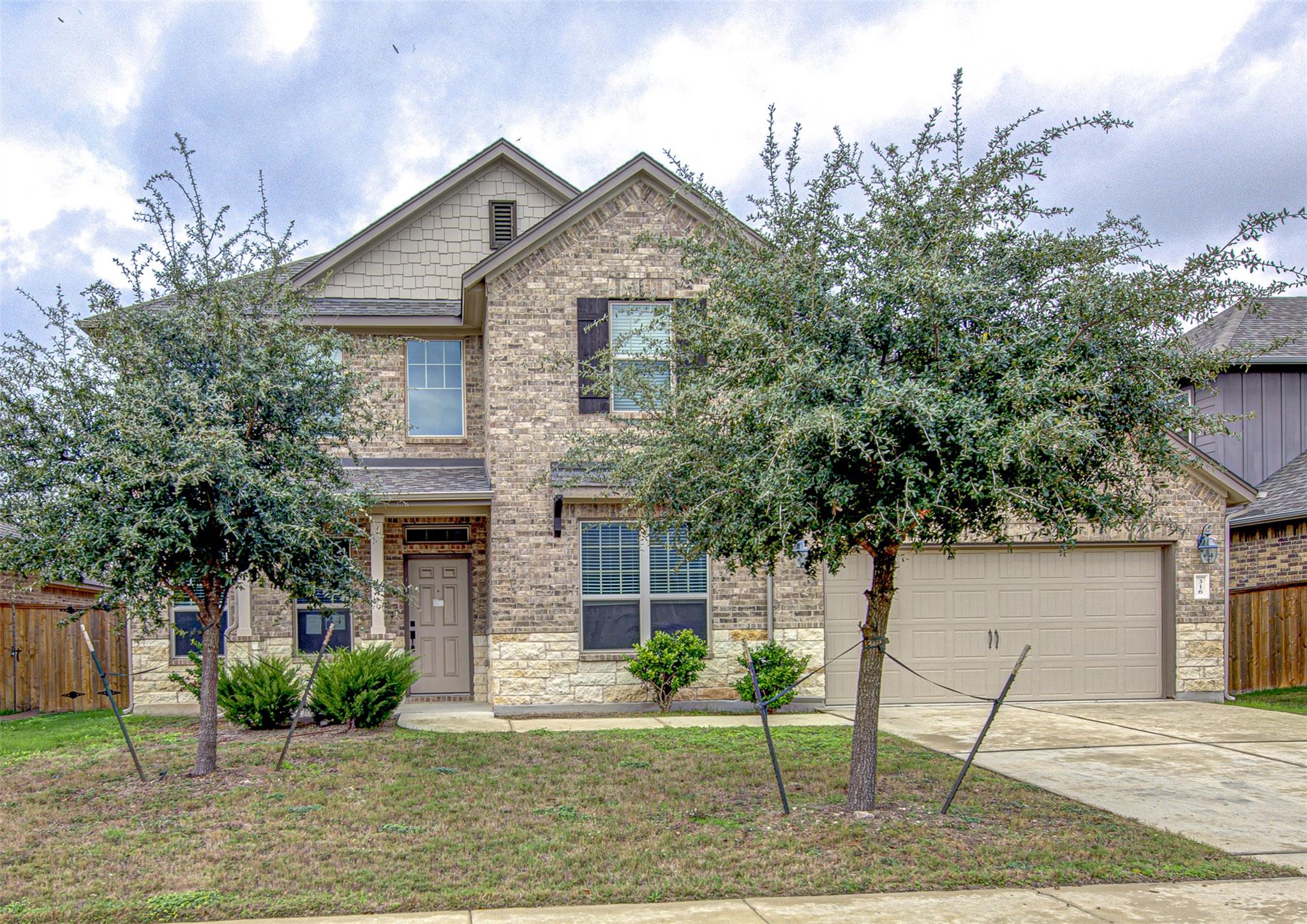 View of front of property featuring driveway, a g