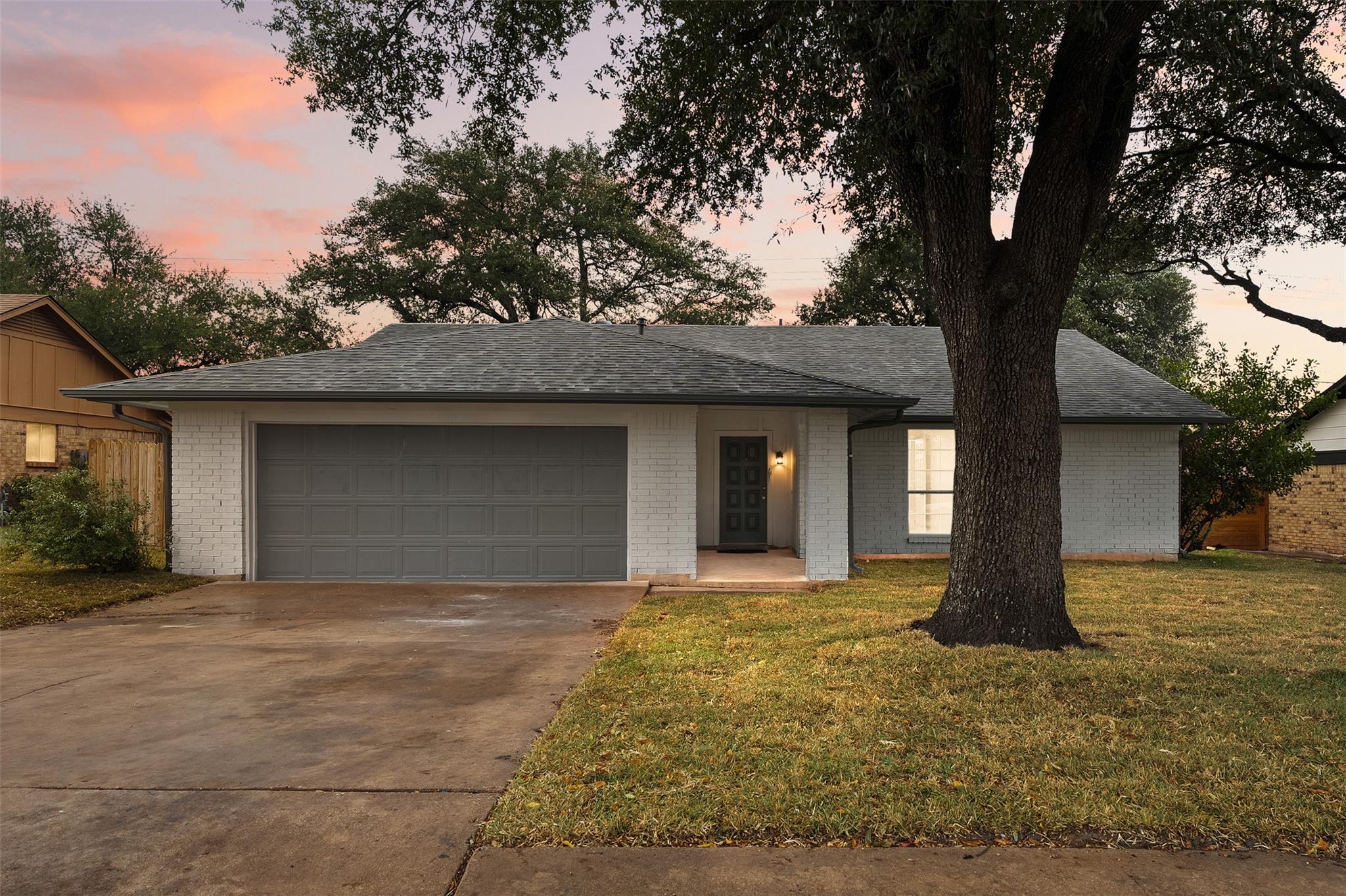 Single story home with a lawn, driveway, a garage