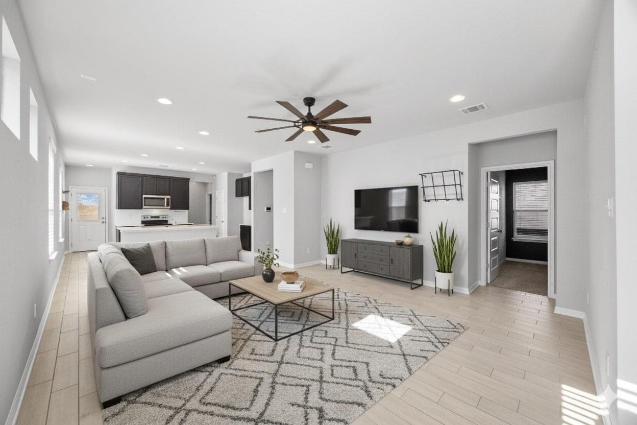 Living room with a ceiling fan, plenty of natural