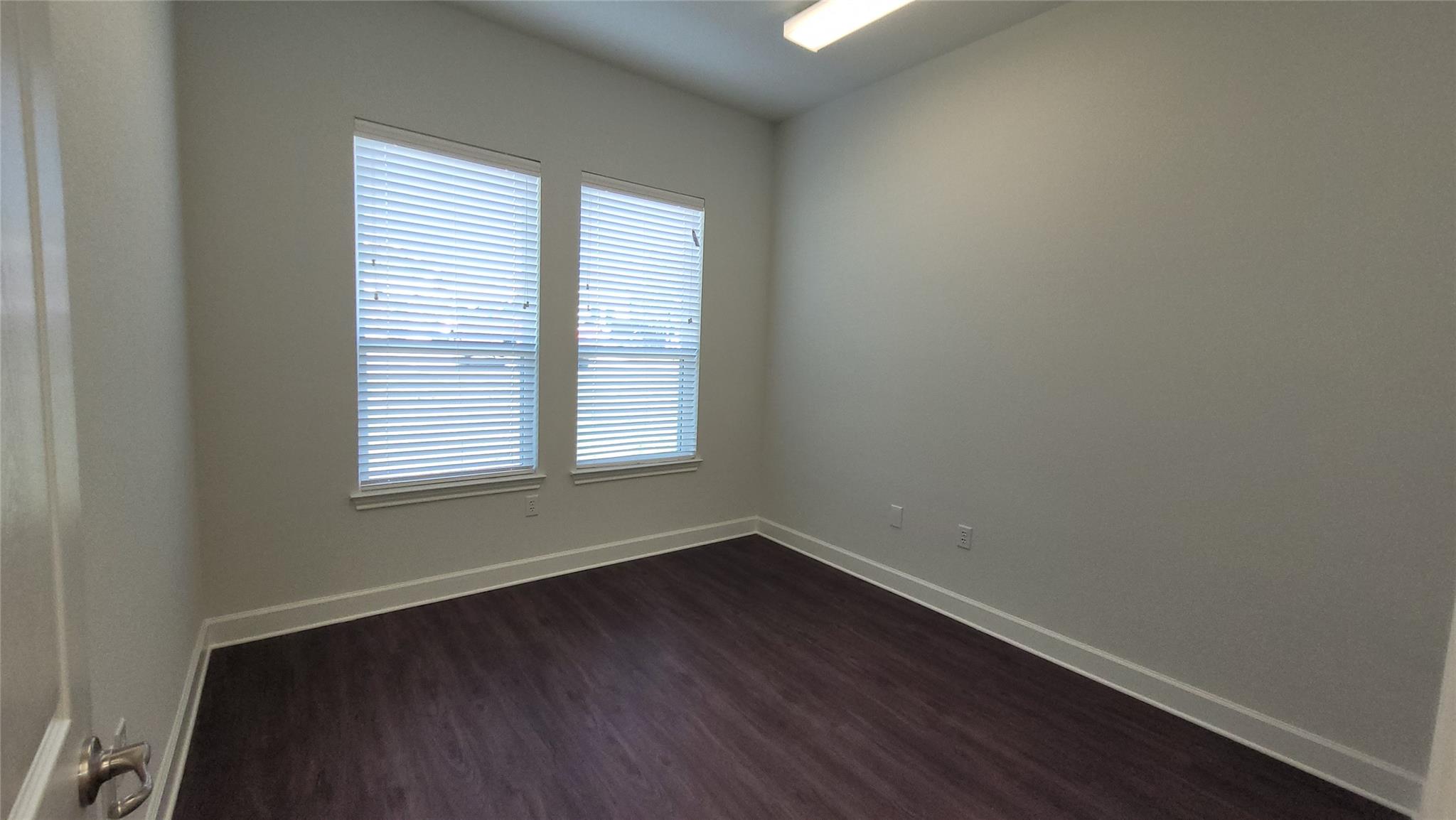 Empty room with baseboards and dark wood finished