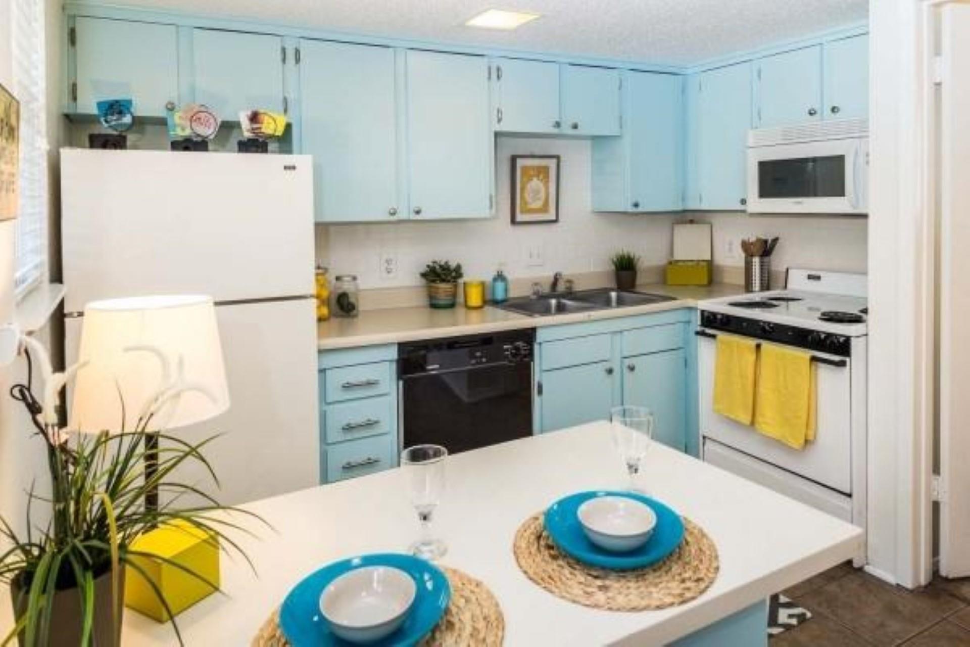Kitchen with blue cabinetry, white appliances, li