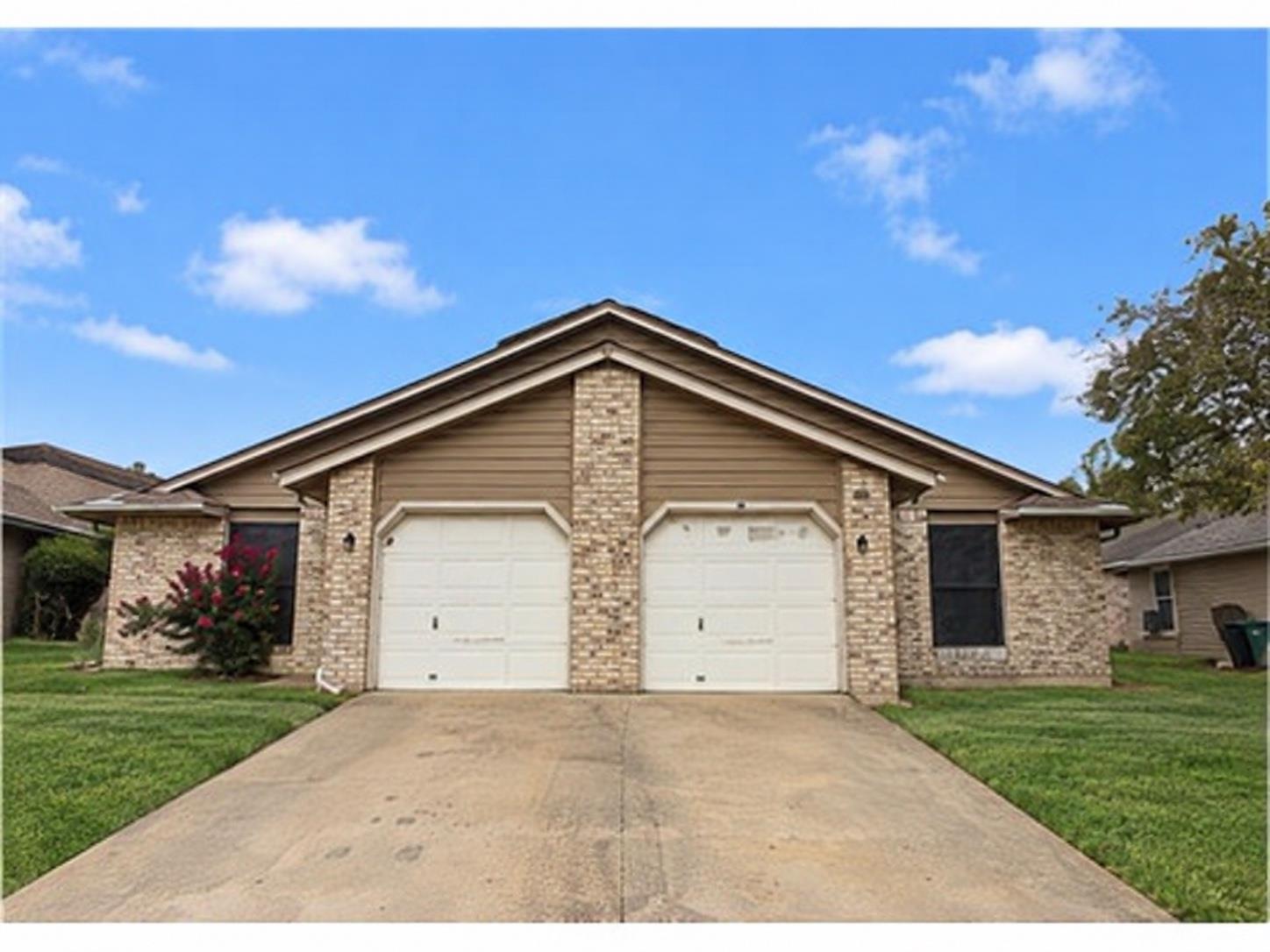 Classic brick accents and a spacious concrete dri