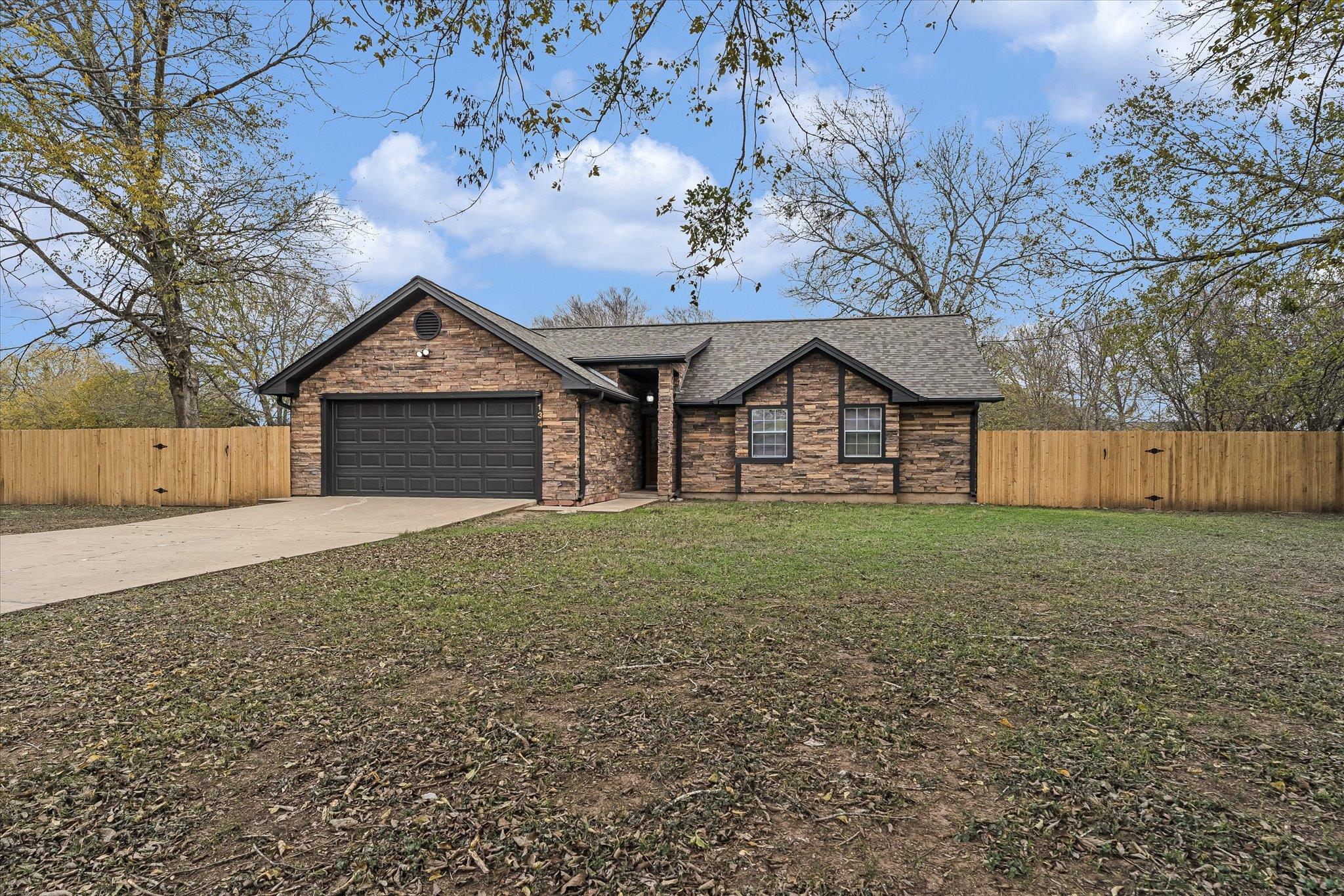 View of front of home with concrete driveway, a g