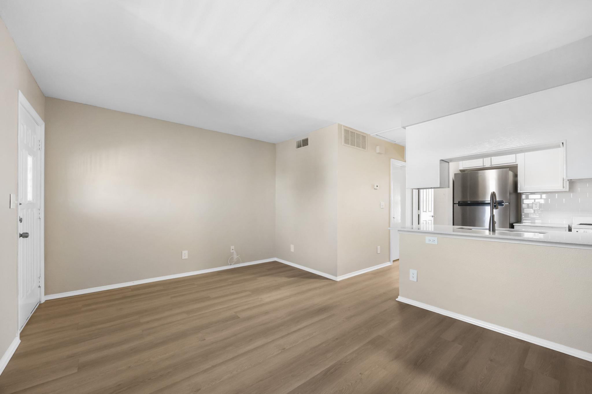 Unfurnished living room with dark wood-style floo