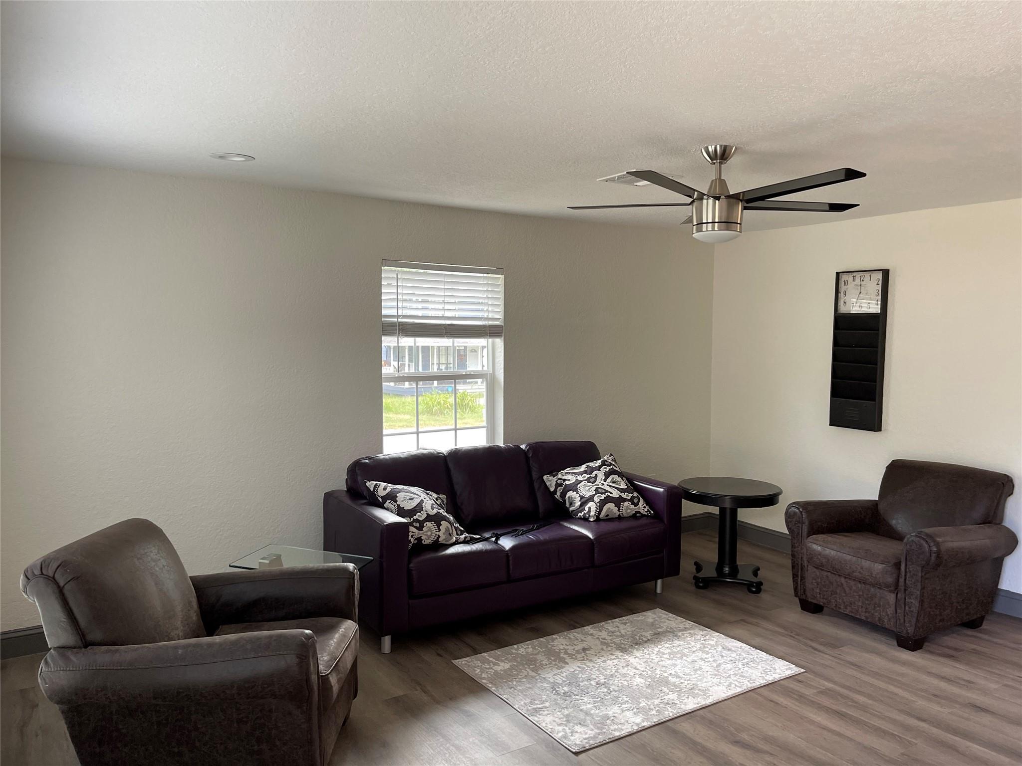 Living room with wood finished floors, a ceiling 