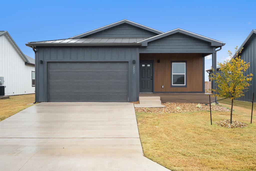 View of front facade featuring a porch, driveway,