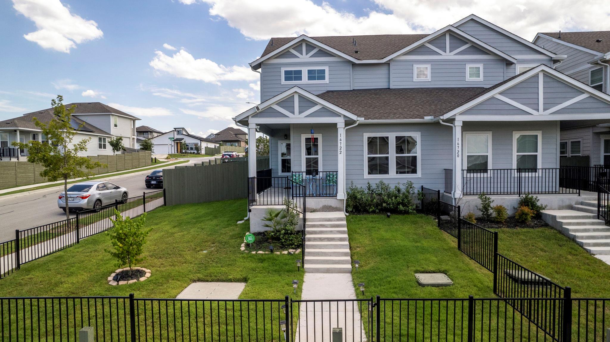 View of front of house featuring a gate, covered 