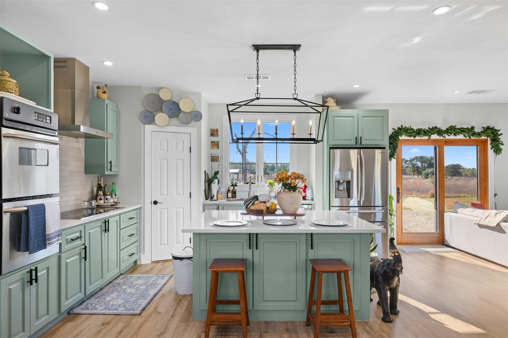 Kitchen featuring green cabinetry, appliances wit
