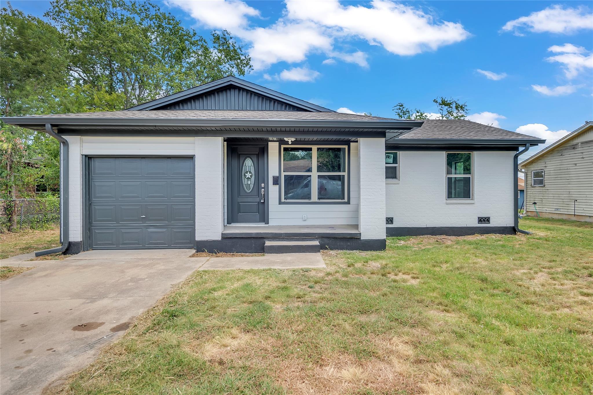 Ranch-style house with concrete driveway, brick s