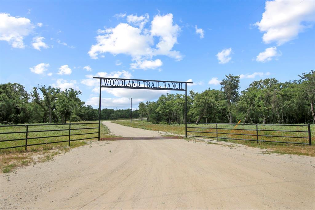 View of dirt / gravel road with a gate and a rura