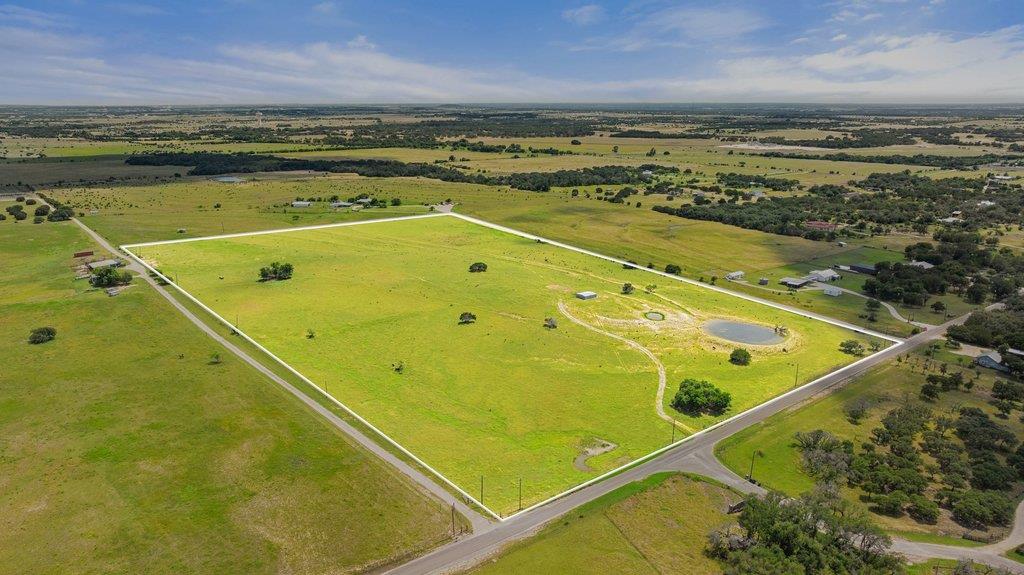 A sprawling rural lot featuring a tranquil pond, 