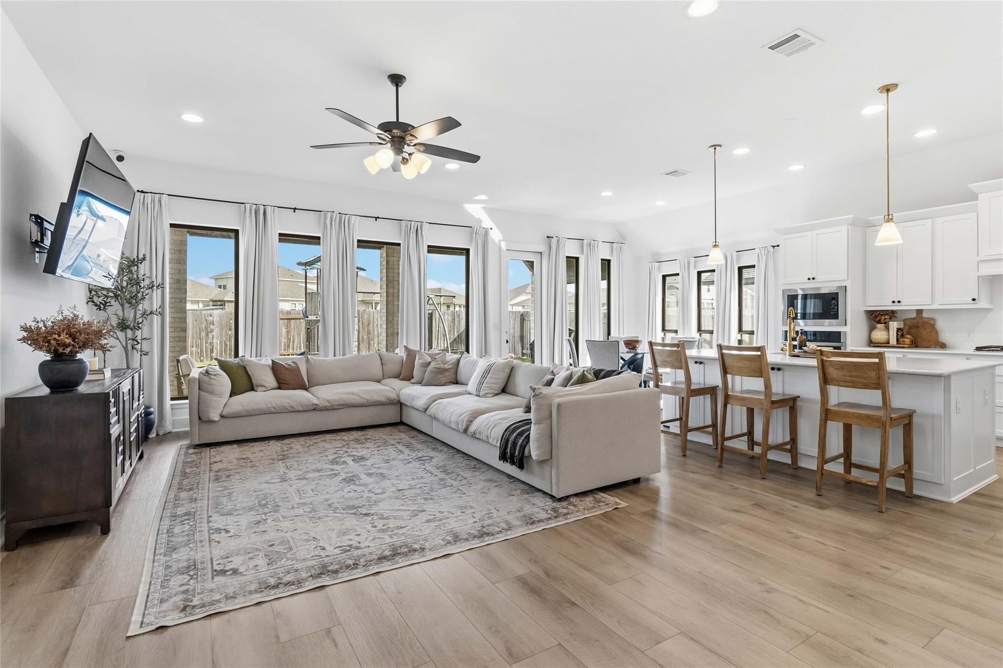 Living room featuring ceiling fan, light wood-sty