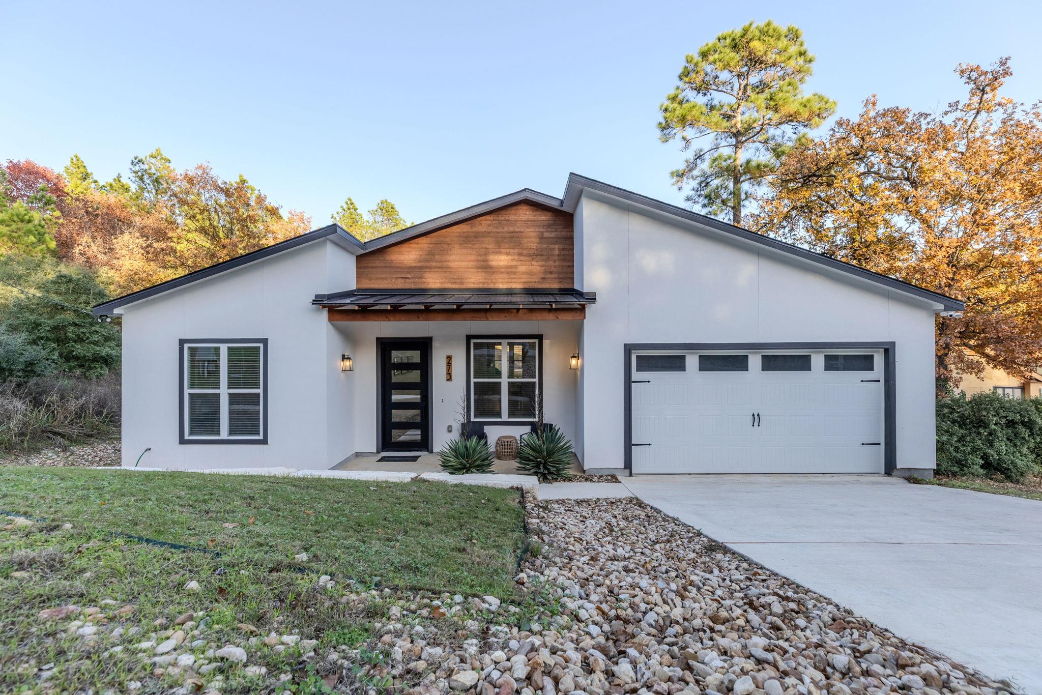 Contemporary house featuring a metal roof, drivew