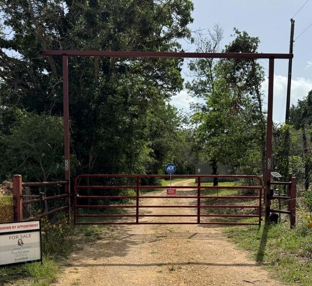 A private gate secures a long, scenic driveway th