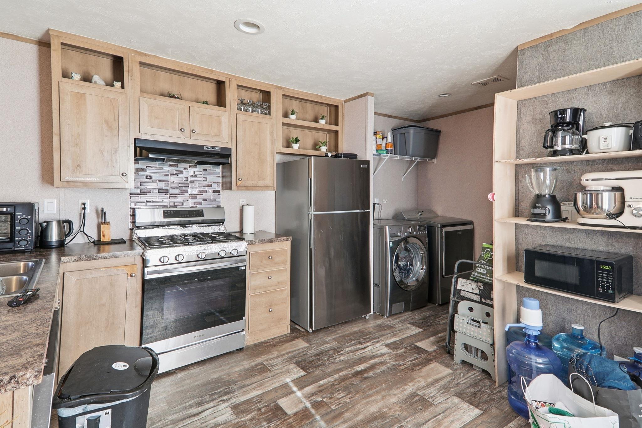 Kitchen featuring light brown cabinetry, stainles
