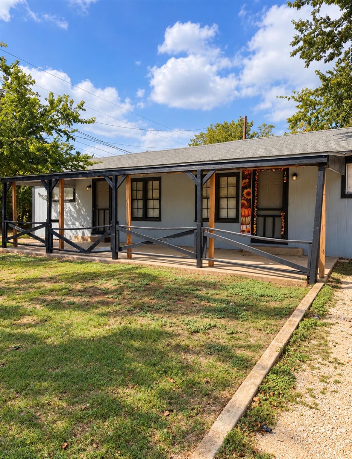 A deep covered porch runs along the front of this