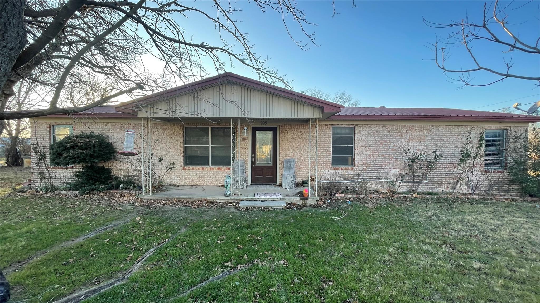 Ranch-style house with covered porch, a front law