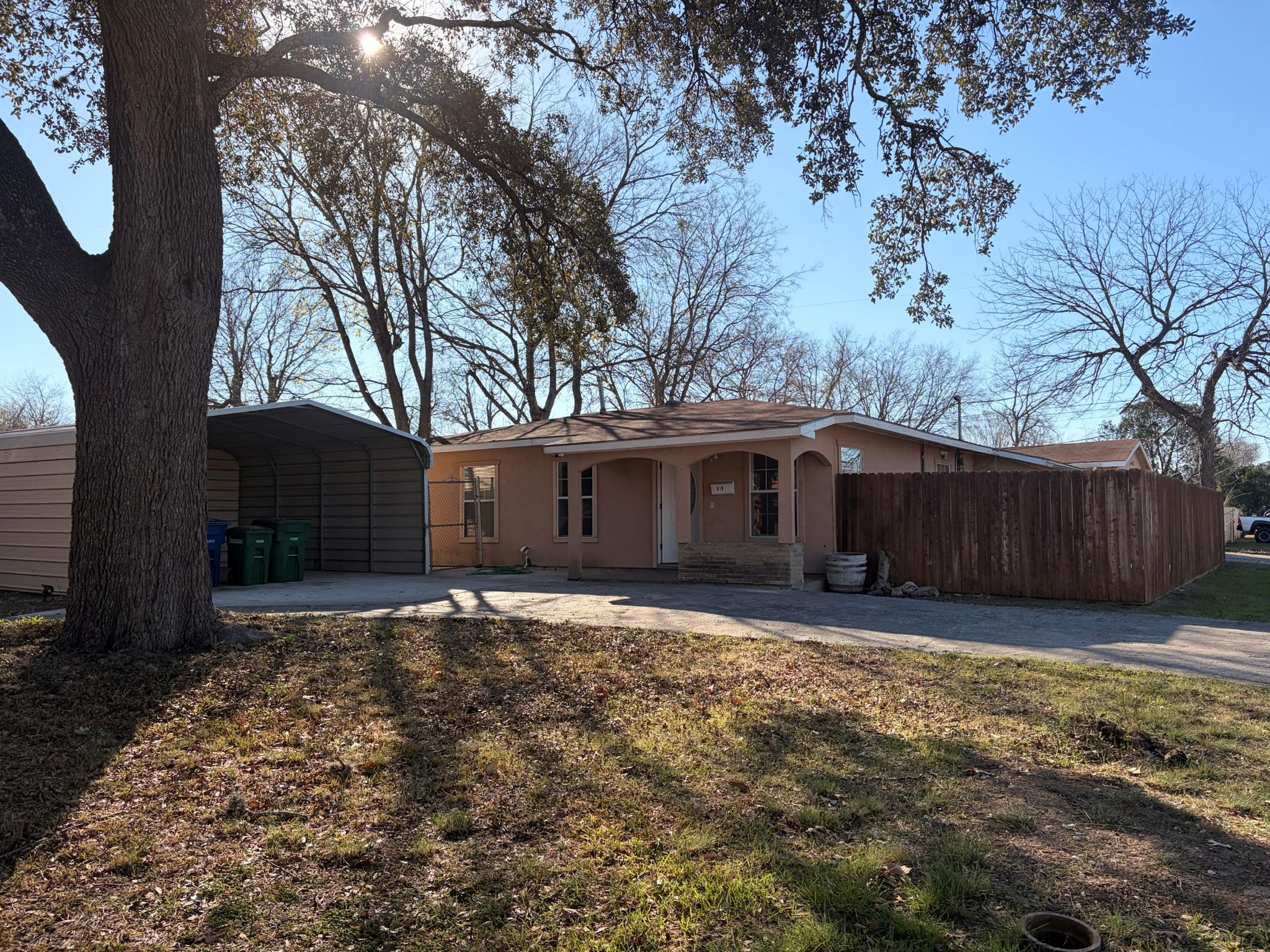 Rear view of house with concrete driveway, a carp