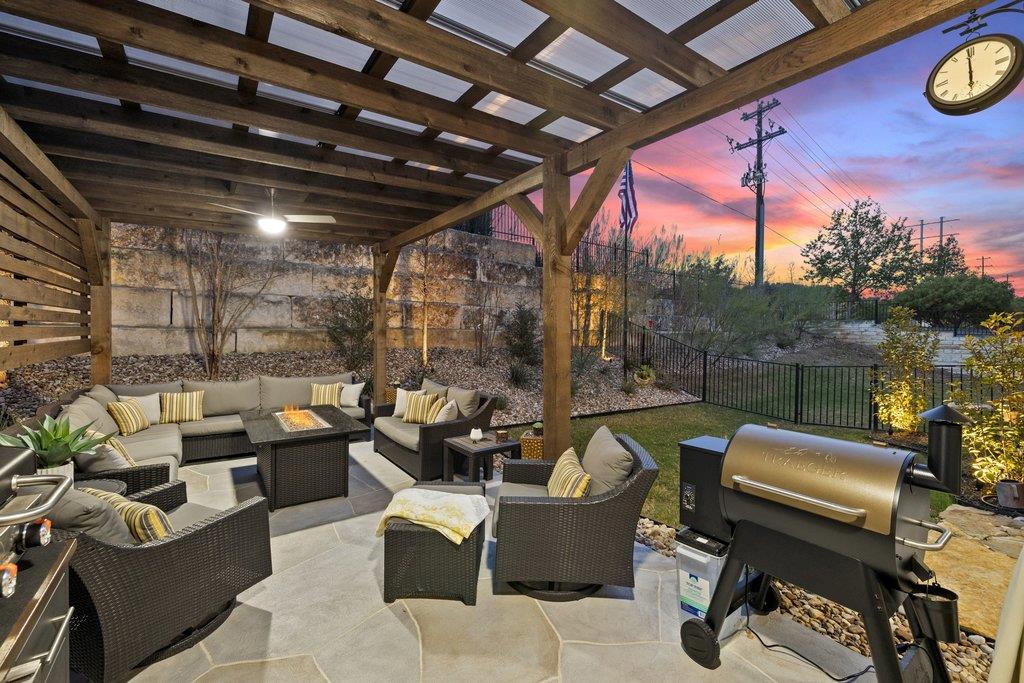 Patio terrace at dusk with a fenced backyard, a p