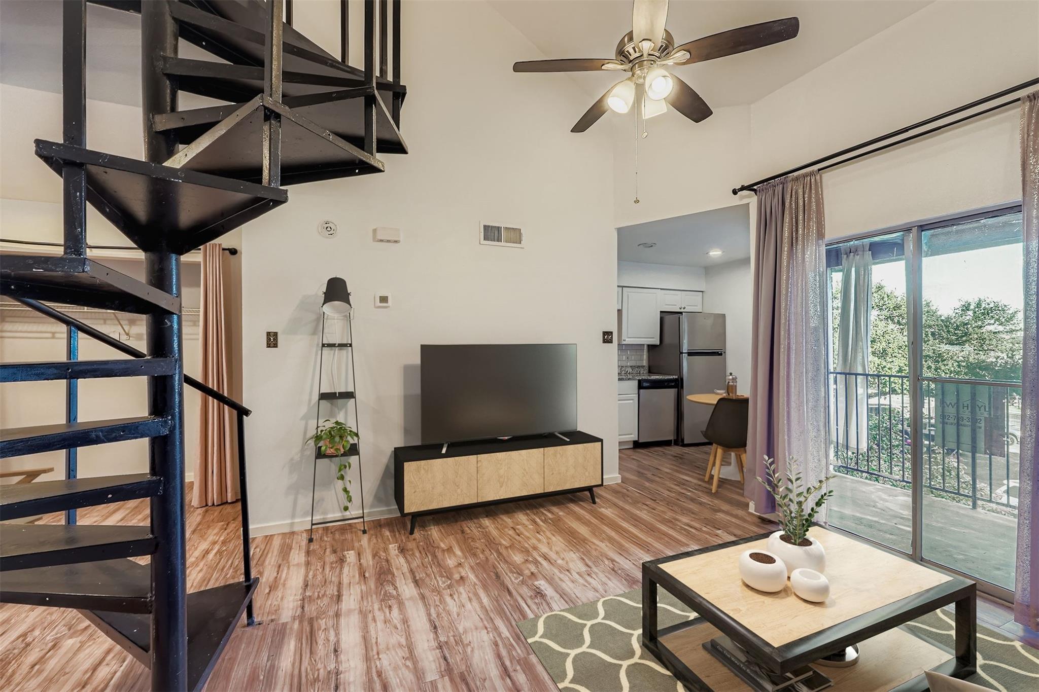 Living room with light wood finished floors, stai
