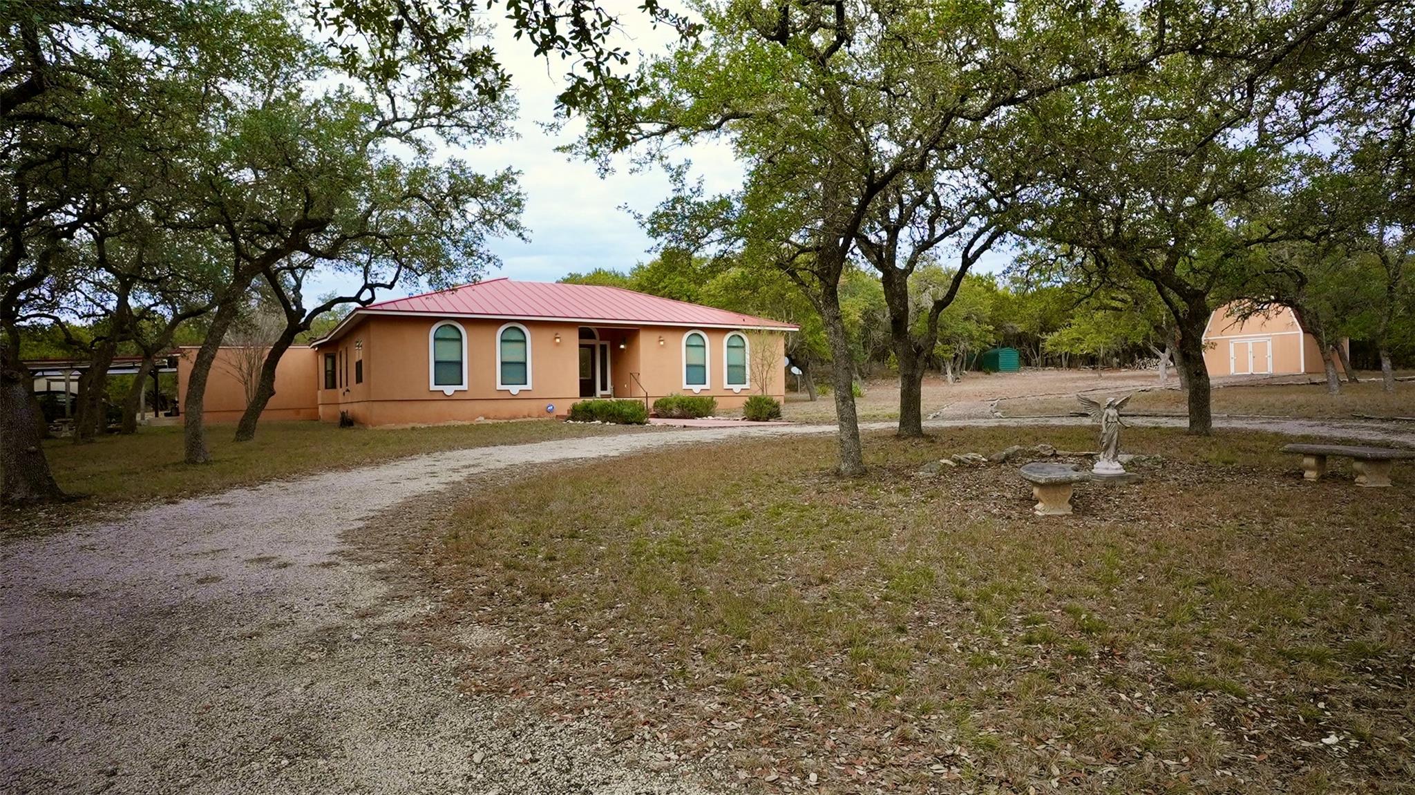View of front facade with a metal roof, driveway,