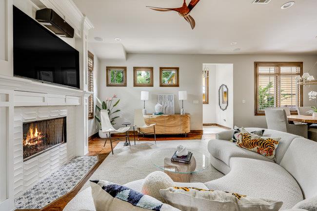 Living room with a ceiling fan, a tiled fireplace